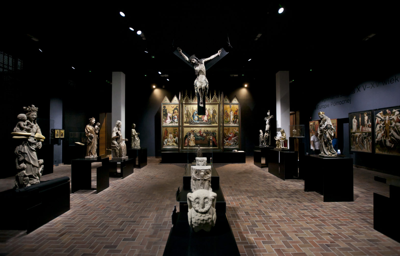 Sala muzealna, na jej końcu stoi tryptyk, przedstawiający motywy religijne, do niego prowadzi szpaler rzeźb świętych. Po środku sali znajdują się rzeźby zwierząt, nad nimi wisi rzeźba ukrzyżowanego Jezusa.