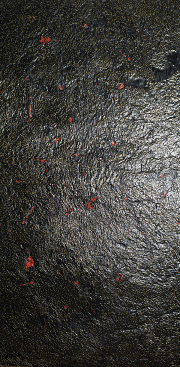 Czarny materiał, wyglądający jak szczyty gór sfotografowane z lotu ptaka, z wystającymi złotymi włoskami. Znajduje się na nim kilka małych czerwonych plam.