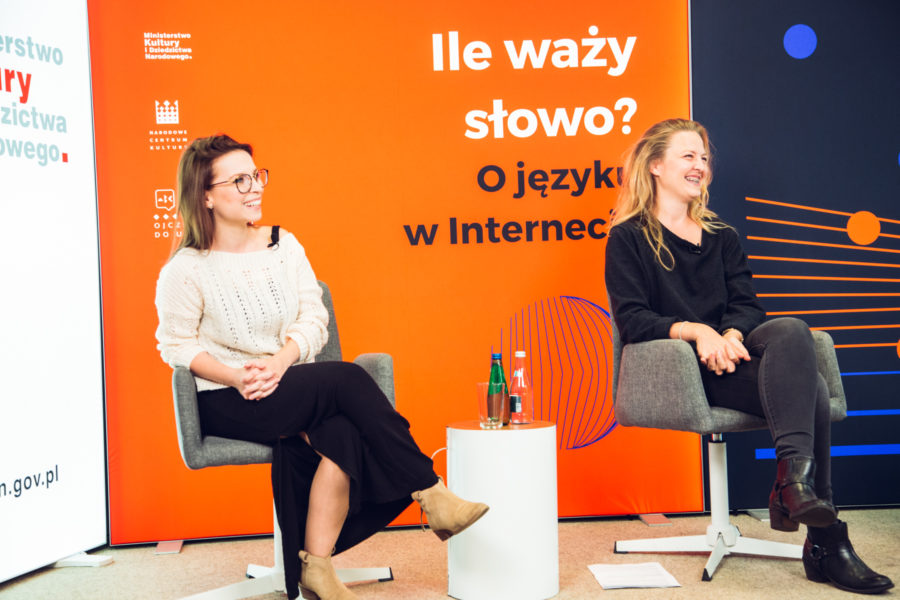Dwie młode kobiety, uczestniczki debaty, śmieją się.
