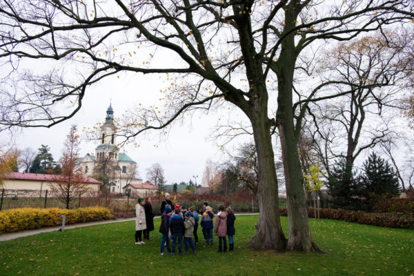 Grupa dzieci jest oprowadza po parku, przez trzy kobiety.